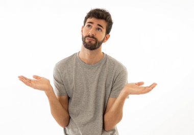 Çekici genç adam portresi hiçbir fikrim yok yüzünde belirsizlik ve habersiz ve sorgulanan bir görünüm ile el ele tutuşarak habersiz jest yapıyor. Beyaz arka planda izole edilmiş. İnsan ifadesi.