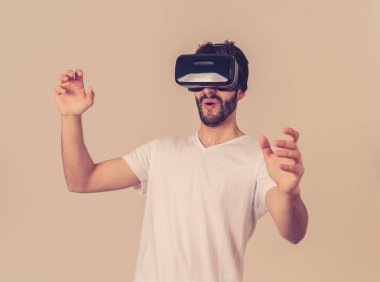 Vr kulaklık gözlük gözlük kullanan Casual sakallı genç adam simülasyon çalışırken heyecanlı hissediyorum, yeni 3d dünya ile etkileşim jestleri yapma sanal gerçeklik keşfetmek. Yeni teknoloji konseptinde.