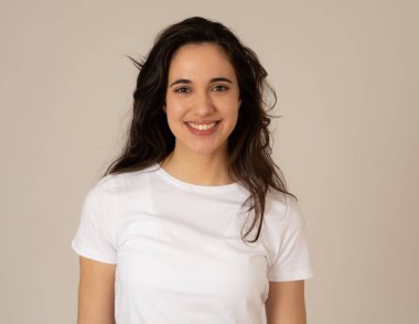 Mutlu yüz güzel gülümseme ve uzun siyah saçlı çekici esmer genç latin kadının yakın portresi. Nötr arka planda izole edilmiş. İnsanlar, pozitif insan yüz ifadesi ve duygu.