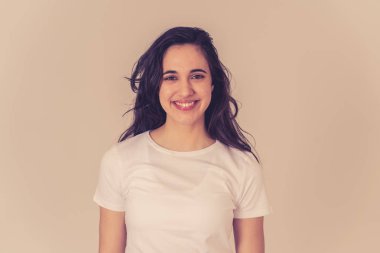 Mutlu yüz güzel gülümseme ve uzun siyah saçlı çekici esmer genç latin kadının yakın portresi. Nötr arka planda izole edilmiş. İnsanlar, pozitif insan yüz ifadesi ve duygu.