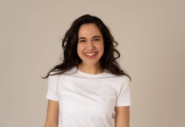 Mutlu yüz güzel gülümseme ve uzun siyah saçlı çekici esmer genç latin kadının yakın portresi. Nötr arka planda izole edilmiş. İnsanlar, pozitif insan yüz ifadesi ve duygu.