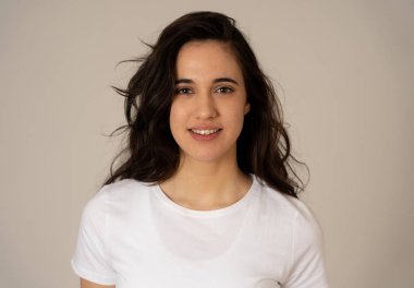 Mutlu yüz güzel gülümseme ve uzun siyah saçlı çekici esmer genç latin kadının yakın portresi. Nötr arka planda izole edilmiş. İnsanlar, pozitif insan yüz ifadesi ve duygu.