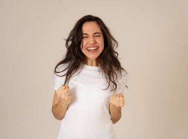 Genç çekici latin kadın kazanan başarı kutluyor ya da silah ile kutlama jestleri yapma şanslı ve neşeli dans hissi. İnsanlar ifadeler ve duygular nötr arka plan izole.