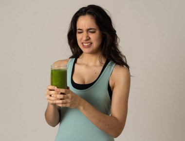Sağlıklı yeşil meyve suyu tutan çekici diyet kız diyet detoks pürüzsüz içecek sıkıcı sevmediğim jestleri gösteren. Sağlıklı gıda, Beslenme fitness ve kilo kaybı kavramı gri arka plan izole.