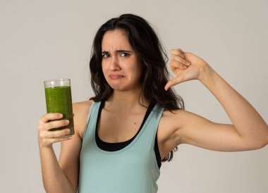 Sağlıklı yeşil meyve suyu tutan çekici diyet kız diyet detoks pürüzsüz içecek sıkıcı sevmediğim jestleri gösteren. Sağlıklı gıda, Beslenme fitness ve kilo kaybı kavramı gri arka plan izole.