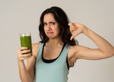 Sağlıklı yeşil meyve suyu tutan çekici diyet kız diyet detoks pürüzsüz içecek sıkıcı sevmediğim jestleri gösteren. Sağlıklı gıda, Beslenme fitness ve kilo kaybı kavramı gri arka plan izole.