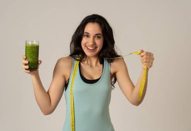 Fitness kadın gevşek kilo diyet planı ile mutlu gülümseyen; egzersiz ve yeşil sebze smoothie sağlıklı içecek. Güzellik vücut bakımı, Sağlık Fitness Diyet Beslenme ve sağlıklı Yaşam tarzı kavramı.