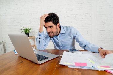 Genç girişimci küçük işletme sahibi faturaları ve yatırım giderleri para sorunları olan ödeme. Öfkeli ve umutsuz adam duygu stüdyo ev ofisinde mali çalışma sırasında stresli.