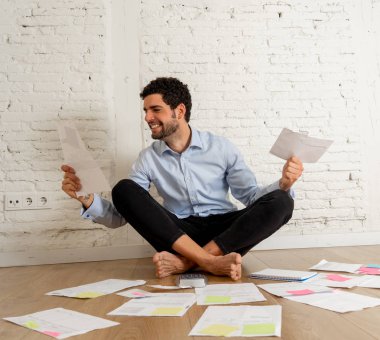 Mutlu başarılı girişimci adam yeni boş stüdyo ofis evde bütçe ve faturaları hesaplanması kağıtları ile çevrili. Küçük işletme sahibi, Finans, Mortgage ve Para finansal planlama kavramı.