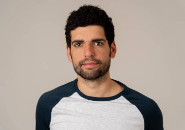 Sakallı ve koyu saçlı doğal ve nötr yüz ifadesi ile genç latin adam yakın headshot. Nötr arka planda izole edilmiş. İnsanlar moda, Lifestyle Güzellik ve İnsan duyguları.