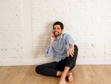 Emlakçı ya da stüdyoda akıllı telefonda ev avcısı adam. Genç hipster sahibi cep telefonuyla yeni boş dairesinde daire kiralamak için konuşuyor. Gayrimenkul yatırım satın alma ve kiralama iş.