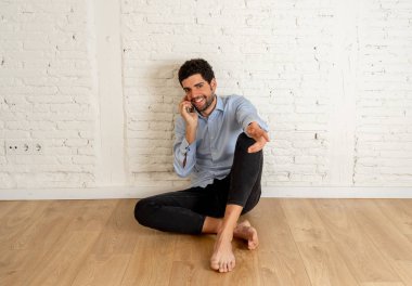Emlakçı ya da stüdyoda akıllı telefonda ev avcısı adam. Genç hipster sahibi cep telefonuyla yeni boş dairesinde daire kiralamak için konuşuyor. Gayrimenkul yatırım satın alma ve kiralama iş.