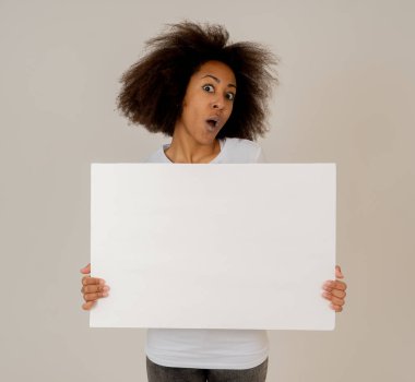 Komik ve güzel afro-amerikan kadın gösteren ve metin için kopya alanı ile boş tahta işaret. Boş poster tutan afro saç stili ile samimi ve heyecanlı kadın. Pazarlama konseptinde.