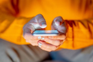 Online oynarken ve metin renkli bir arka plan ile akıllı telefon üzerinden ekran telefon bağımlılığı Internet oyun bağlantısı ve yeni teknoloji ışık göndererek genç veya yetişkin kadın kapatmak.
