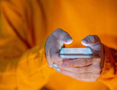 Genç kadın veya genç renkli arka plan ve ekran ışığında Internet ve mobil bağımlılığı Cyberbullying iletişim içinde sosyal medya app ve Modern teknoloji kavramı üzerinde metin gönderme.