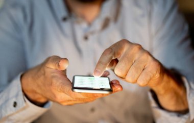 Online oynarken ve metin renkli bir arka plan ile akıllı telefon üzerinden ekran telefon bağımlılığı Internet oyun bağlantısı ve yeni teknoloji ışık göndererek genç veya yetişkin insanın yakın çekim.