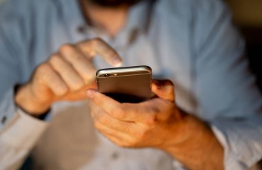 Online oynarken ve metin renkli bir arka plan ile akıllı telefon üzerinden ekran telefon bağımlılığı Internet oyun bağlantısı ve yeni teknoloji ışık göndererek genç veya yetişkin insanın yakın çekim.