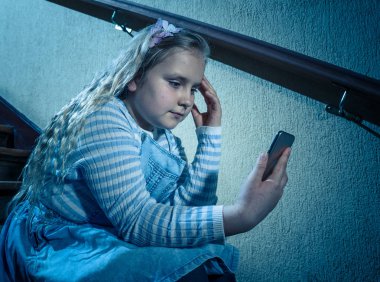 Üzücü depresif kız metin mesajı sınıf arkadaşları tarafından aşağılanmış Online sosyal medya tarafından bullied. Yalnız umutsuz duygu merdivenlerden oturan cep telefonu tarafından siber zorbalık üzücü depresif genç kız kurbanı.