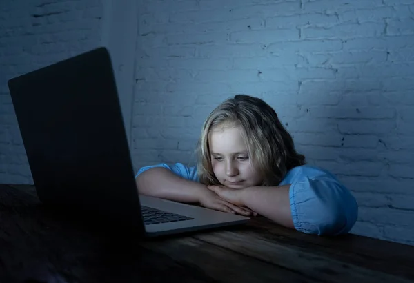 Scared sad girl bullied on line with laptop suffering cyber bullying harassment feeling desperate and intimidated. Child victim of bullying stalker social media network and the dangers of internet.