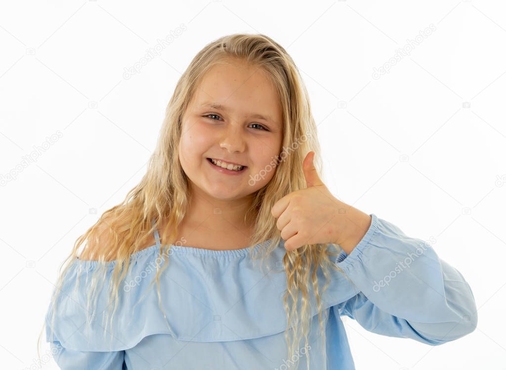 Portrait of young schoolgirl feeling happy smiling and making thumbs up gesture. Isolated on neutral background. In Education Children, Human expressions and body language.