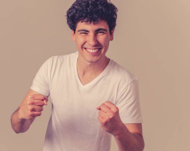 Başarıyı kutlayan genç adamın portresi, bir futbol golü, piyangoyu kazanmak ya da büyük başarılar elde etmek, bağırmak ve mutluluk içinde gesturing. Yüz ifadesi ve Olumlu insan duyguları.