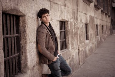 Çekici şık genç adam kentsel Avrupa şehir açık havada moda ve şık giysileri ile kameraya bakarak şehvetli poz. In People güzellik Gençlik moda trendleri ve Avrupa'da seyahat.