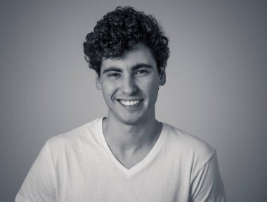 Mutlu genç adamın kameraya gülümseyerek ve gülerek eğlenen ve neşe içinde olan portresini kapatın. İnsanlarda Pozitif İnsan duyguları, yüz ifadeleri, mutluluk ve gençlik güzellik kavramı.