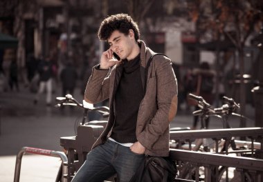 Söz ve akıllı telefon üzerinde sosyal medya arkadaşıyla tatil günlerinde Avrupa'da sohbet mutlu onun yirmili genç çekici adam. İletişim, teknoloji internet ve yaşam tarzı konsepti.