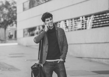 Söz ve akıllı telefon üzerinde sosyal medya arkadaşıyla tatil günlerinde Avrupa'da sohbet mutlu onun yirmili genç çekici adam. İletişim, teknoloji internet ve yaşam tarzı konsepti.