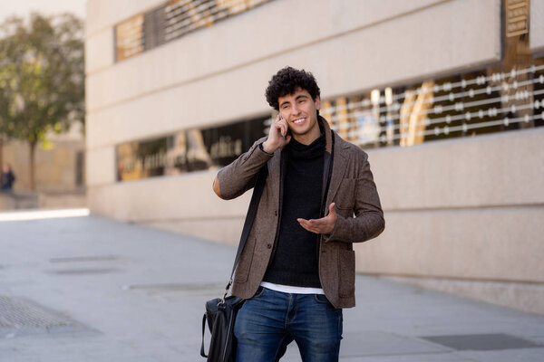 Young attractive man in his twenties happy talking and chatting with friend on social media on smart phone on holidays in europe. In communication, technology internet and lifestyle concept.