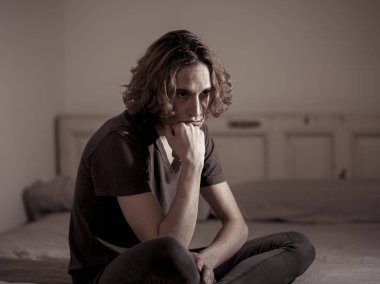 Harap bin yıllık adam üzgün duygu acı ve umutsuz acı Depresyon ağlıyor. Geceleri umutsuzluk içinde yatakta tek başına oturan zorbalık veya istismar depresif genç kurbanı. Genç Ruh sağlığı.