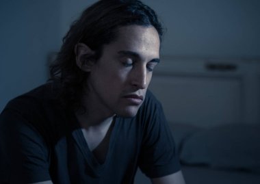 Harap bin yıllık adam üzgün duygu acı ve umutsuz acı Depresyon ağlıyor. Geceleri umutsuzluk içinde yatakta tek başına oturan zorbalık veya istismar depresif genç kurbanı. Genç Ruh sağlığı.
