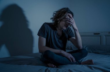 Harap bin yıllık adam üzgün duygu acı ve umutsuz acı Depresyon ağlıyor. Geceleri umutsuzluk içinde yatakta tek başına oturan zorbalık veya istismar depresif genç kurbanı. Genç Ruh sağlığı.