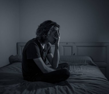 Harap bin yıllık adam üzgün duygu acı ve umutsuz acı Depresyon ağlıyor. Geceleri umutsuzluk içinde yatakta tek başına oturan zorbalık veya istismar depresif genç kurbanı. Genç Ruh sağlığı.
