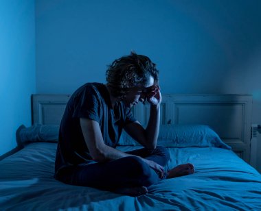 Harap bin yıllık adam üzgün duygu acı ve umutsuz acı Depresyon ağlıyor. Geceleri umutsuzluk içinde yatakta tek başına oturan zorbalık veya istismar depresif genç kurbanı. Genç Ruh sağlığı.