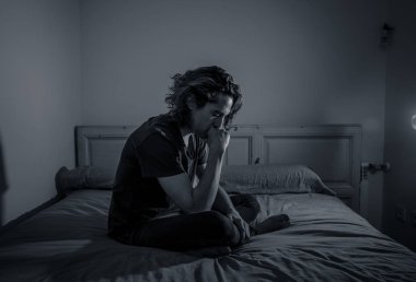 Harap bin yıllık adam üzgün duygu acı ve umutsuz acı Depresyon ağlıyor. Geceleri umutsuzluk içinde yatakta tek başına oturan zorbalık veya istismar depresif genç kurbanı. Genç Ruh sağlığı.