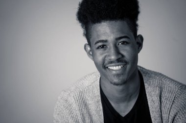 Siyah arka plan karşı rahat giysiler içinde poz genç çekici şık afro-amerikan genç erkek modeli portresi afro saçlı seksi görünümlü. In People Youth Güzellik ve moda konsepti.