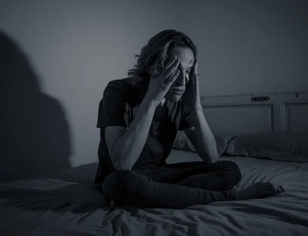 Devastated millennial man crying sad feeling hurt and hopeless suffering Depression. Depressed teenager victim of bullying or abuse sitting on bed alone in despair at night. In teenage Mental health.