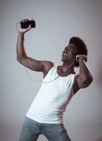 强壮的非洲裔美国青年舞蹈家听音乐在线跳舞和唱歌与耳机 艺术肖像与迪斯科舞池霓虹灯在网络音乐和技术概念 — 图库照片