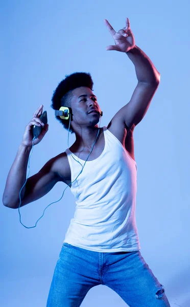 强壮的非洲裔美国青年舞蹈家听音乐在线跳舞和唱歌与耳机 艺术肖像与迪斯科舞池霓虹灯在网络音乐和技术概念 — 图库照片