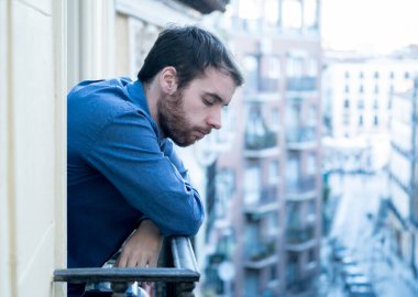 Yalnız üzgün adam ev balkonun depresif sıkıntı ve sefil hissi dışarı bakıyor. Erkekler depresyon ve zihinsel sağlık zor önemli yaşam kararı hakkında düşünme acı duygusal kriz.