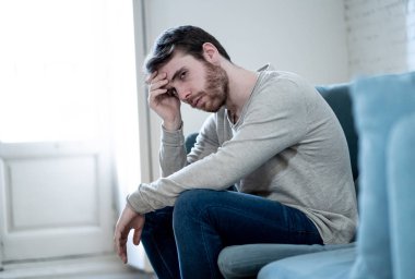 Mutsuz beyaz erkek oturan ve oturma odası kanepede yatarken depresif depresyonu yalnız bir acı duygu çaresiz. İş, anksiyete, kalbi kırık ve erkekler sağlık kavramı vurguladı içinde.