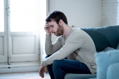 Mutsuz beyaz erkek oturan ve oturma odası kanepede yatarken depresif depresyonu yalnız bir acı duygu çaresiz. İş, anksiyete, kalbi kırık ve erkekler sağlık kavramı vurguladı içinde.