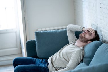Mutsuz beyaz erkek oturan ve oturma odası kanepede yatarken depresif depresyonu yalnız bir acı duygu çaresiz. İş, anksiyete, kalbi kırık ve erkekler sağlık kavramı vurguladı içinde.