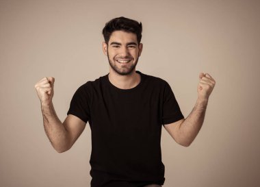 Genç adam onun hedefe ulaşmak, piyango yeme veya yüz ifade insan duyguları ve gri izole ve mutlu yüz ifadesi büyük bir başarı olan kutluyor portresi.