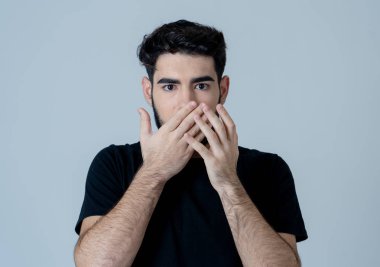 Genç adam korkuyor ve korku anksiyete jestleri yapma şok hissediyor. Korkmuş ve çaresiz görünümlü kendini örtbas etmeye çalışıyor. Kopya alanı ile portre. İnsanlar ve ınsan ifadeleri ve duygular.