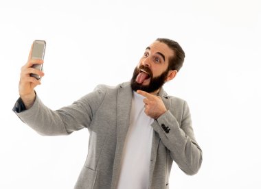 Genç çekici bir hippi elinde kamera ya da cep telefonu ile selfie çekiyor ya da takipçileri için video kaydediyor. Teknoloji, İnternet sosyal medya ağı ve blog işi kavramında.