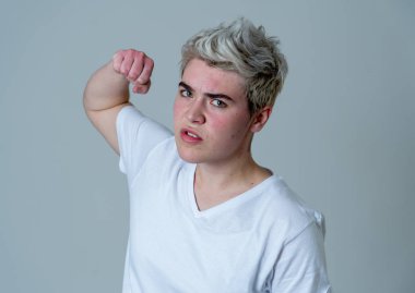 Kızgın yüzü ile genç çekici transseksüel genç adam Portresi. Kızgın ve öfkeli görünüyorsun. Yüz ifadeleri ve duygular. Nötr arka planda yalıtılmış.