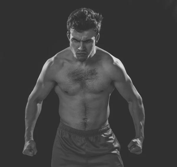 強烈な激しい表情を持つ強い筋肉のスポーツマンの肖像画 ワークアウト トレーニング フィットネスの概念で黒の背景に強力に見える表現力豊かなセクシーなシャツレス怒っている男 — ストック写真