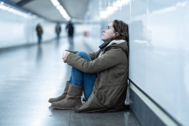 Genç Yetişkin utanç felling depresif ve umutsuz tek başına oturmak içinde depresyon yalnızlık ruh sağlığı zemin Metro City duygusal ağrı sosyal şiddet edici ilişki ve taciz kavramı.